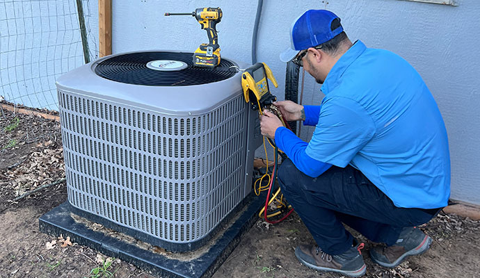 Professional technician is installing an outdoor air conditioning unit
